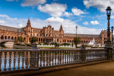 SEVILLA, İSPA - Haziran 2020. Seville 'deki İspanya Meydanı Plaza de Espana Panoraması' nda kanal, göl, çeşme, kuleler ve binanın ana girişi üzerinde köprüler bulunmaktadır. Mağribi ve Rönesans canlandırması örneği.