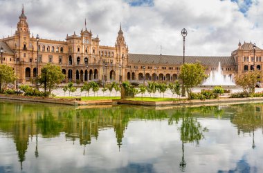 SEVILLA, İSPA - Haziran 2020. Seville 'deki İspanya Meydanı Plaza de Espana Panoraması' nda kanal, göl, çeşme, kuleler ve binanın ana girişi üzerinde köprüler bulunmaktadır. Mağribi ve Rönesans canlandırması örneği.