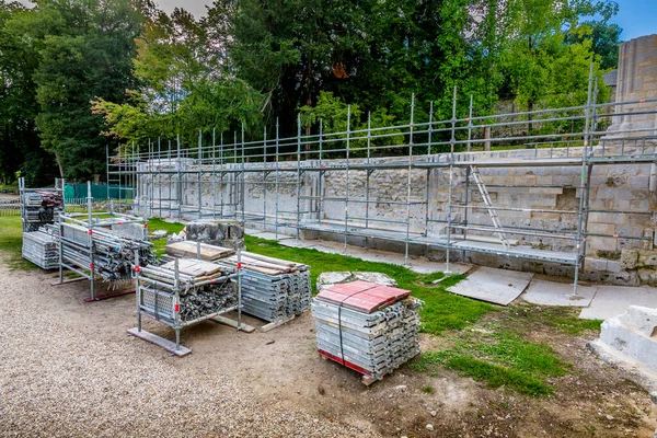 Piles of new square hollow section galvanused steel pipes and tubes with anti rust oil coating. Applications in scaffoldings, trolleys, cabins, fencing, etc. Background is a wall with scaling — Stock Image Piles New Square Hollow Section Galvanused Steel Pipes Tubes Rust Stock Photo