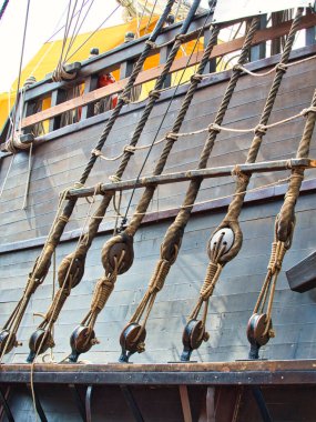 Eski uzun geminin donanımları ve donanımları. Yelkenli teknenin direğine halat ve ip merdiveni yerleştirmek, deniz konseptinizin soyut arka planıdır..