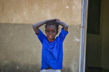SENEGAL, AFRICA - MARSCH Circa, 2016. Senegal 'de çok fakir olan Afrikalı çocukların tanımlanamayan portresi. Yüzünde duygular var. Canlı renkler