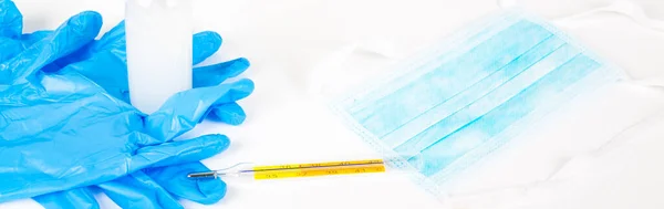 Blue gloves hand gel mask thermometer on white background. The set to use each time you go out to stop coronavirus world pandemy. Copy space