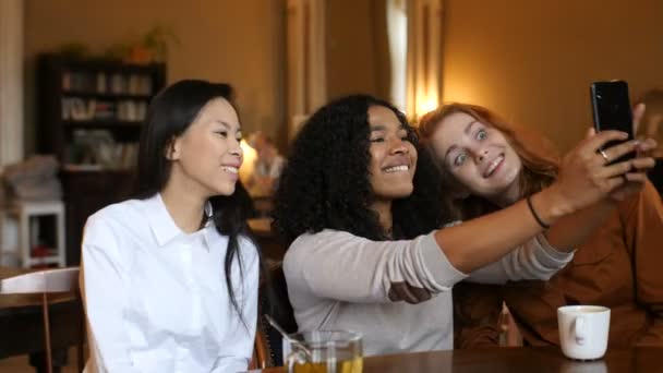 Multi étnica meninas telefone inteligente tecnologia chamada de vídeo no café — Vídeo de Stock