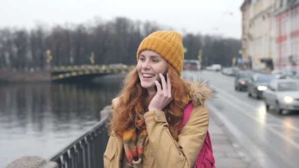 Jonge rode haren Kaukasische vrouw lopen straat praten op mobiele telefoon In de stad — Stockvideo