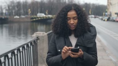 Sokak City 4 k cep telefonuyla konuşan yürüyen genç Afro-Amerikan siyah kadın