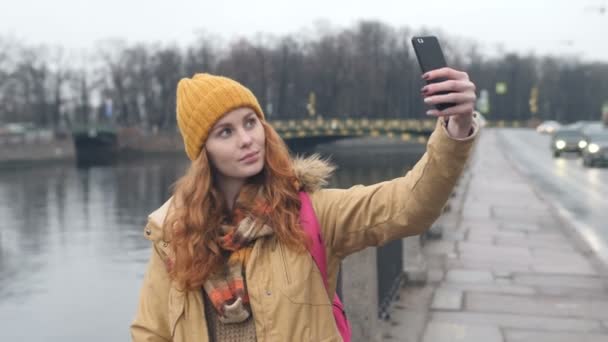 Giovane donna caucasica capelli rossi prendendo selfie in città — Video Stock