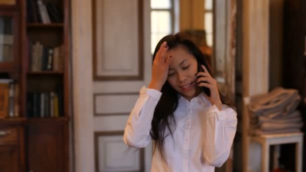 Junge asiatische Frau, die im Café mit dem Handy telefoniert — Stockvideo