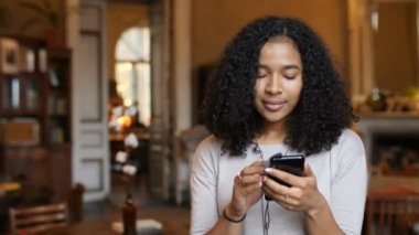 Genç Afro-Amerikan siyah kadın müzik telefonu ve Cafe 4 k dansları dinler