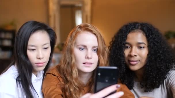Interethnic group of girls actively rooting for football, looking at the smartphone and enjoy the victory — Stock Video