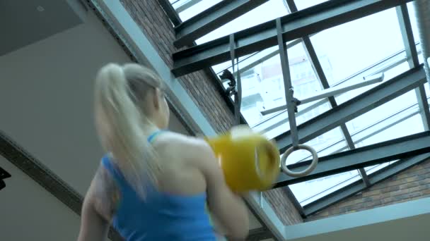 Meisje in de sportschool, liften metalen gewichten en frodrinking met inspanning. — Stockvideo