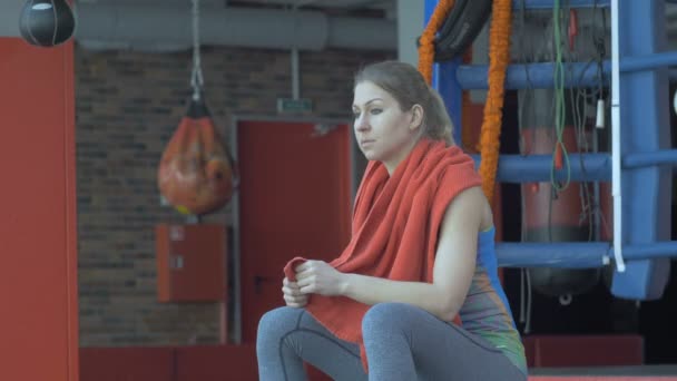Vacker kvinna torka hennes hals med en handduk efter träningspass på gymmet — Stockvideo