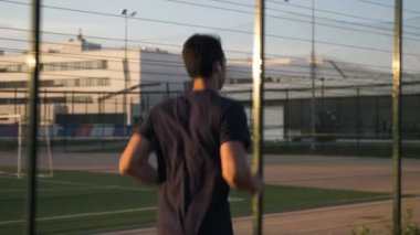 Gün doğumunda koşmak için pistte koşan bir atlet.