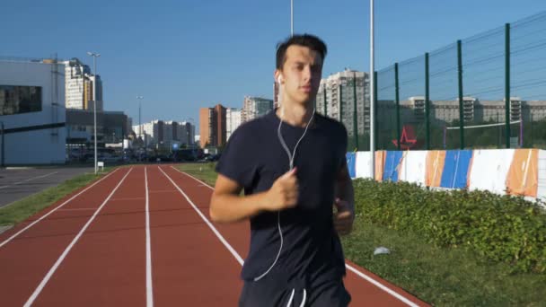 Sportler läuft bei Sonnenaufgang auf der Bahn. — Stockvideo