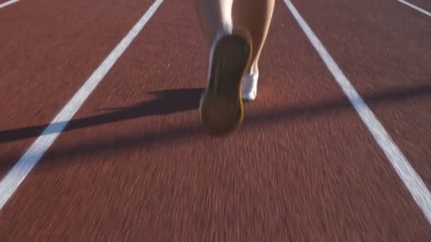 Gün doğumunda koşmak için pistte koşan bir atlet. — Stok video