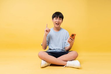 Genç adam elleri ve elleri çapraz bağlı oturuyor. Gözleri açık. Parmağını uzatarak bir keşif önerisinde bulunuyor.