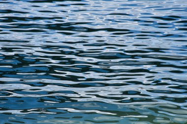 Gündüz gökyüzü, sakin nehir suyuna yumuşak dalgalanmalarla yansıyarak soyut doğal dokuları görünür kara ve kıyı olmaksızın oluşturur..