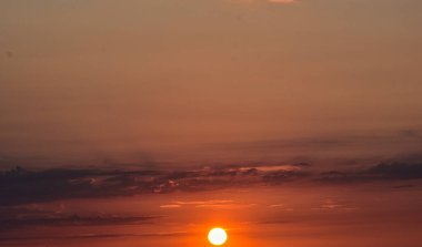Ufukta parlayan güneşle gün batımı, sihirli, renkli gökyüzü sıcak tonlarla dolu, huzurlu ve rüya gibi bir atmosfer yaratıyor..