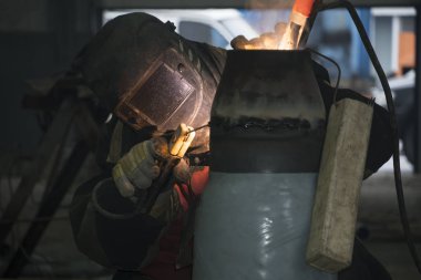 Bir kaynakçı teknolojik boru hatları ile Rusya'da bir petrol rafinerisi için manuel ark kaynak. Kaynaklı bağlantı.