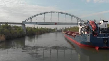 Volgograd, Rusya-27 Nisan 2019. Su taşımacılığı ile nakliye. Nehir-deniz tipi motorlu gemi, St.George Victorious kargo gemisi demiryolu köprüsü altında duruyor, kilitleme onun dönüş bekliyor.