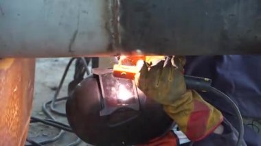 Bir kaynakçı teknolojik boru hatları ile Rusya'da bir petrol rafinerisi için manuel ark kaynak. Kaynaklı bağlantı.