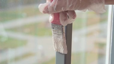 Beyaz boyayla metal yapıları fırçayla boyamak.