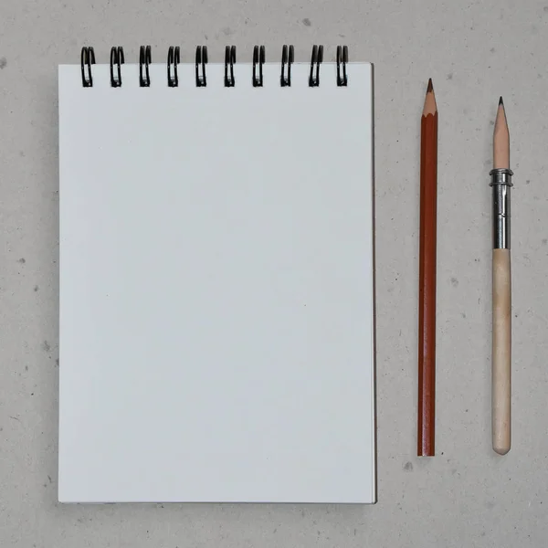 Clear sheet note book and colour pencils on craft background.