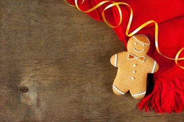 Kırmızı bir eşarp ile ahşap bir masa üzerinde Noel zencefilli kurabiye. Üstten görünüm.