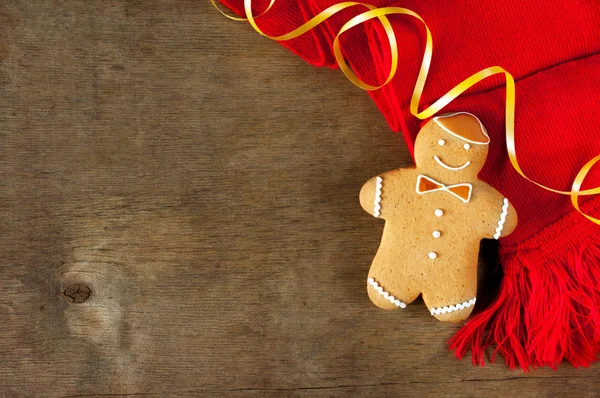 Kırmızı bir eşarp ile ahşap bir masa üzerinde Noel zencefilli kurabiye. Üstten görünüm.