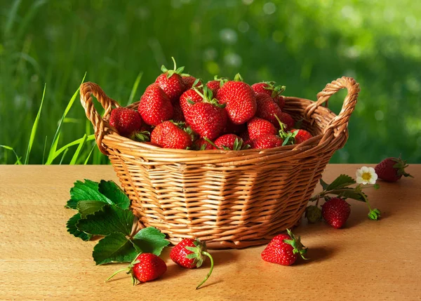 Akan bir ahşap masada bir sepet içinde Olgun çilek çilek