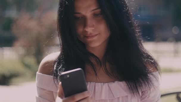 Πορτρέτο της νεαρής κυρίας σε ένα δρόμο της πόλης το καλοκαίρι χρησιμοποιώντας smartphone — Αρχείο Βίντεο