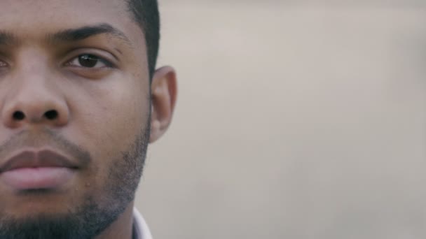 Halve gezicht portret van jonge African American man buiten — Stockvideo