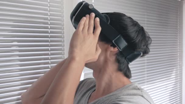 Ung man använder hans Vr-headset för att titta på en 360-video på office bakgrund. Närbild. — Stockvideo