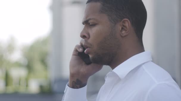 Retrato del hombre de negocios afroamericano enojado se comunica agresivamente por teléfono — Vídeos de Stock