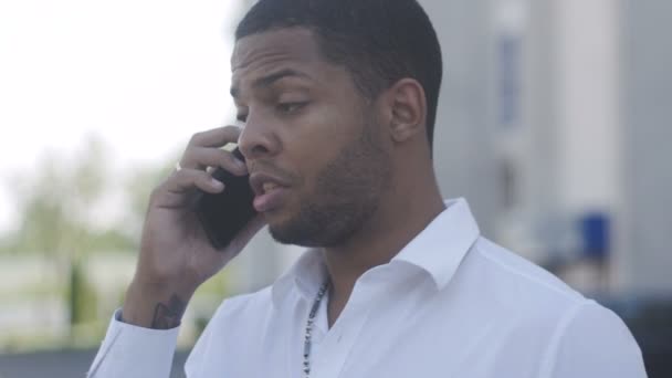 Portrait of Angry African American man aggressively communicates by phone — Stock Video