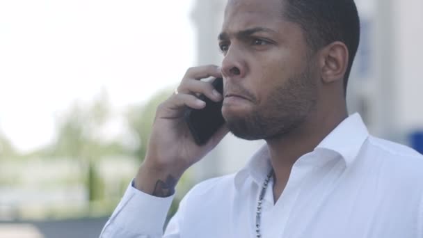 African American man aggressively communicates by phone — Stock Video