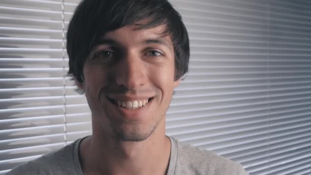 Portrait of positive young man smiling at office background — Stock Video