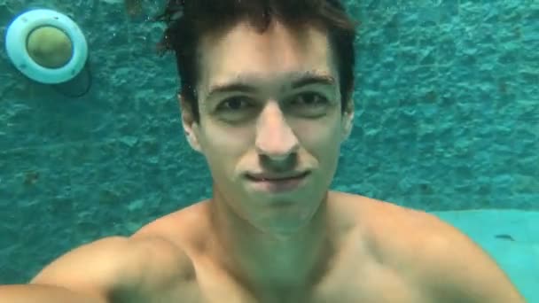 Homem a fazer selfi enquanto mergulha na piscina. Natação subaquática. Guy nada na bacia — Vídeo de Stock