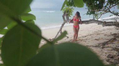 okyanusun bir arka plan üzerinde tropik sahilde bir Mayo Bikini genç bir kadın portresi. Slowmotion