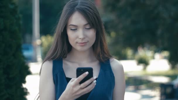 Porträtt av ung vacker kvinna med smartphone utomhuspool på gatan bakgrund — Stockvideo