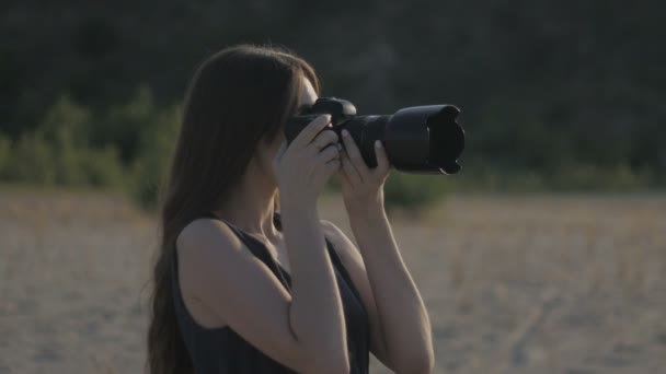 Όμορφη νεαρή γυναίκα δημοσιογράφος στη στέπα. Κορίτσι με μια φωτογραφική μηχανή σε ένα σαφάρι. — Αρχείο Βίντεο