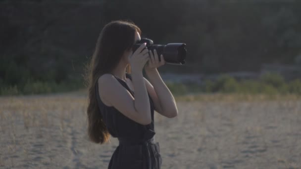 Kadın Foto muhabiri profesyonel bir kamera ile doğanın bir fotoğrafı çeker. Kız bir atış yapma ve fotoğraf fotoğraf makinesi üzerinde seyir — Stok video