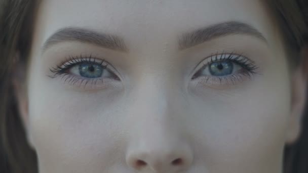 Close-up shot of young womans blue eyes with light day make-up outdoor — Stock Video