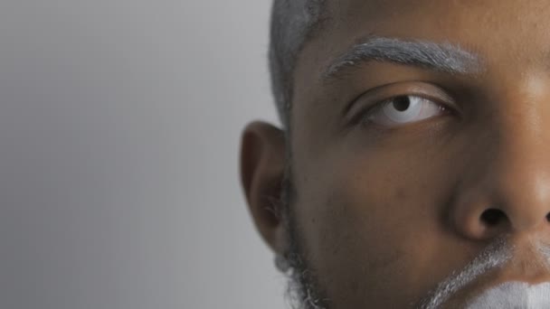 Μισό πρόσωπο πορτρέτο του δαιμονική Αφροαμερικανός άντρας με λευκά μάτια και τα χείλη — Αρχείο Βίντεο