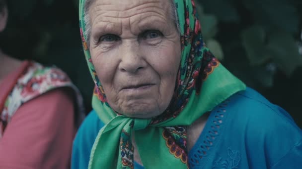 Portrait de très vieille femme seule dans un foulard au jardin extérieur — Video