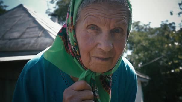 Donna molto vecchia da sola in una sciarpa in giardino all'aperto — Video Stock