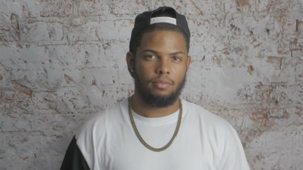 Portrait of afro american rapper hip hopper in cap looking at camera — Stock Video