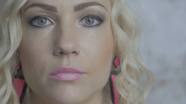 Närbild porträtt av vackra unga blonda kvinnan tittar på kameran — Stockvideo