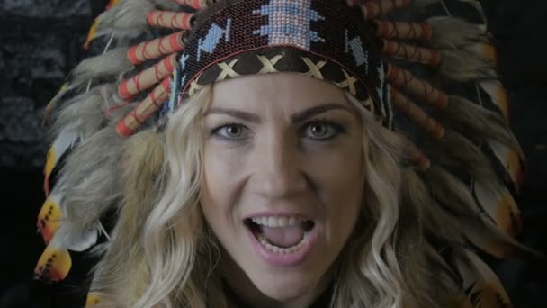 Close up portrait of red indian woman hunter with feathers on her head screams — Stock Video