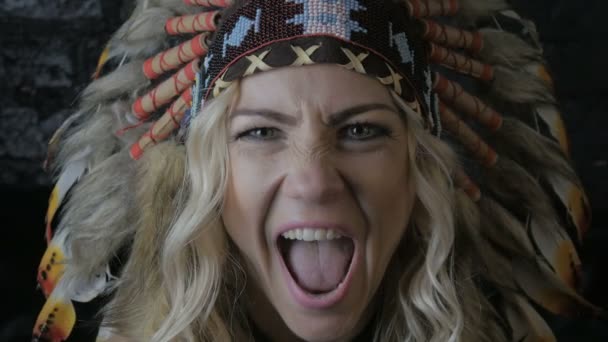 Close up portrait of red indian woman hunter with feathers on her head screams — Stock Video