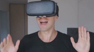 Oturma odasında 360 video evde izlemek için Vr kulaklığı kullanan genç adam. Yakın çekim.